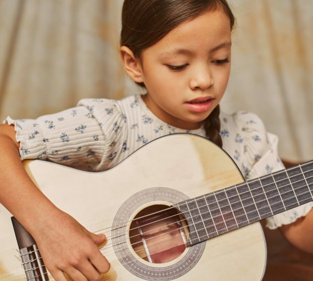 little-girl-learning-how-play-guitar-home